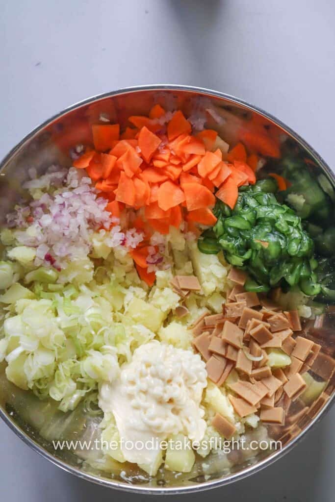 Cooled mashed potatoes mixed with cucumber, carrot, vegan ham, scallions, and onion