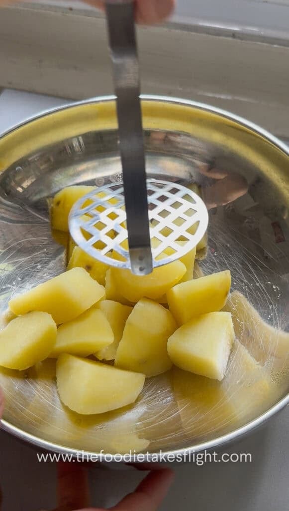 mashing cooked potatoes