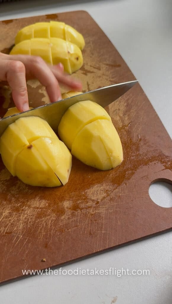 slicing whole peeled potatoes