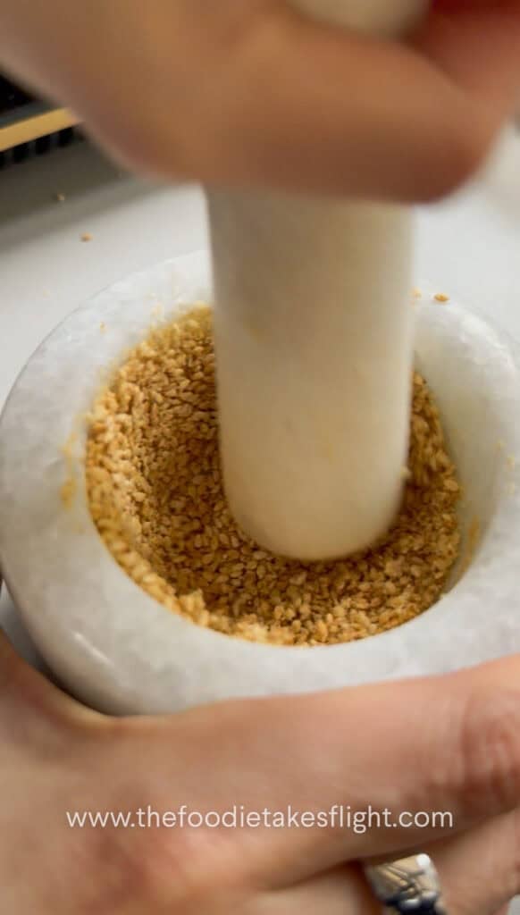 Warm toasted sesame seeds crushed in a mortar and pestle