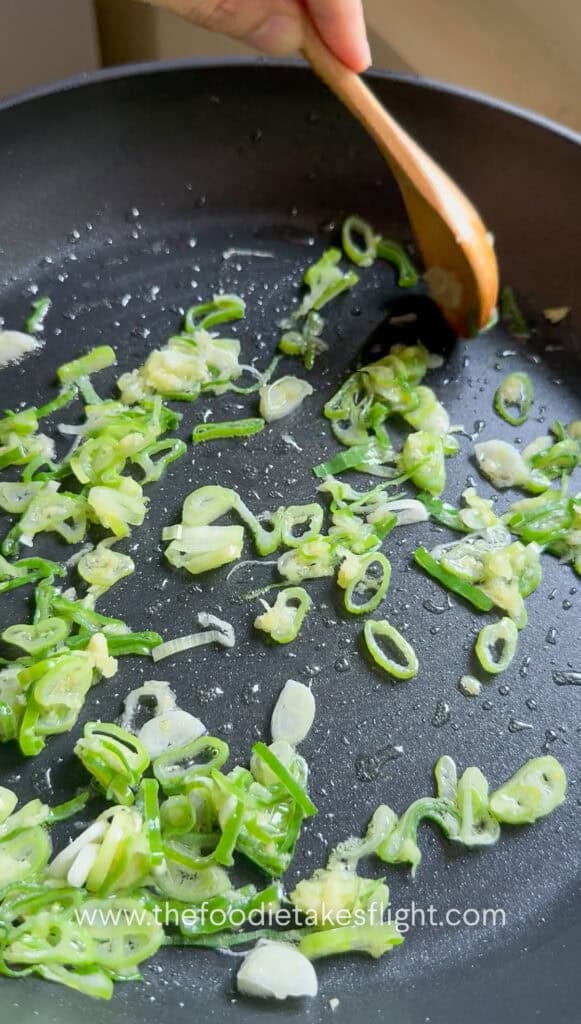 Scallions and grated ginger cooking in hot oil until aromatic