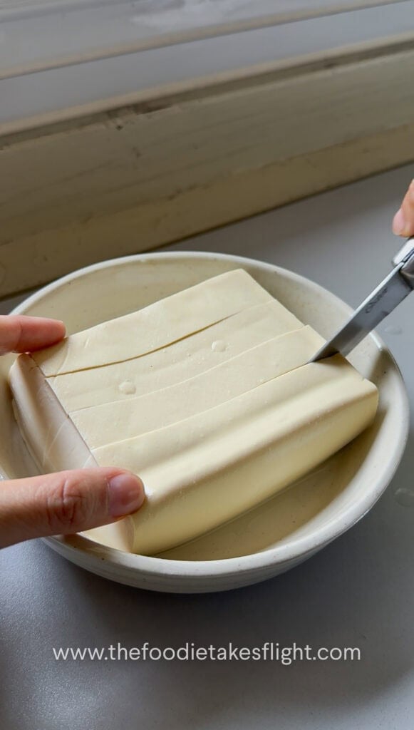 Silken tofu sliced into a shallow checkered grid pattern without cutting all the way through