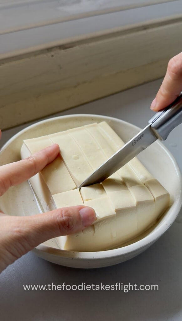 Silken tofu sliced into a shallow checkered grid pattern without cutting all the way through