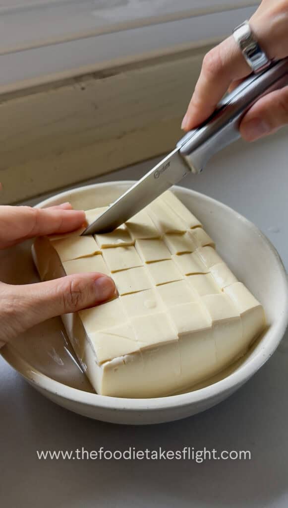 Silken tofu sliced into a shallow checkered grid pattern without cutting all the way through