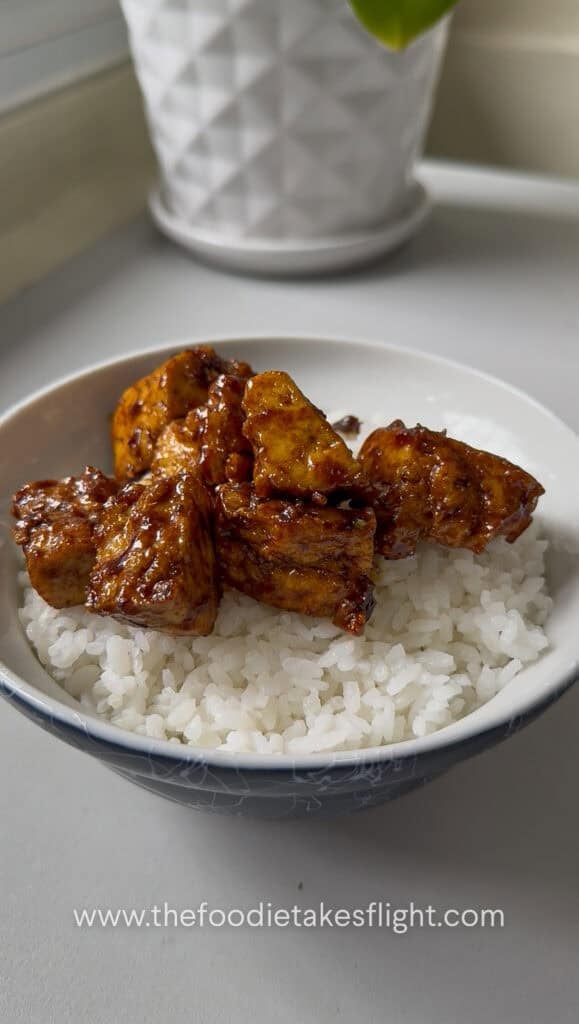 Sticky tofu served over a bowl of steamed rice