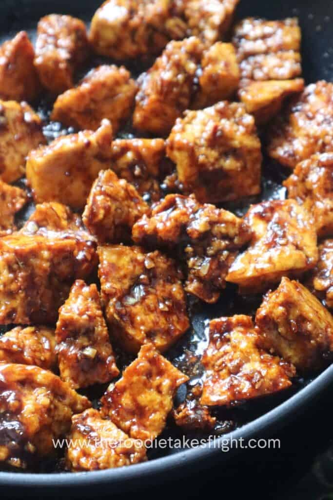 a pan full of crispy hand-torn tofu in glossy hoisin sauce