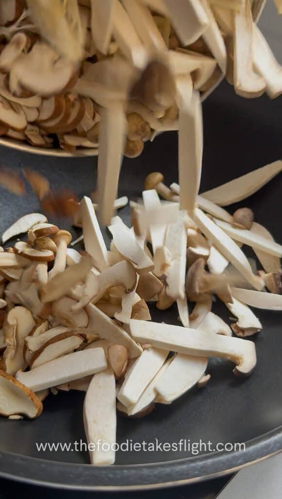 Mushrooms cooking in a dry wok until they release moisture