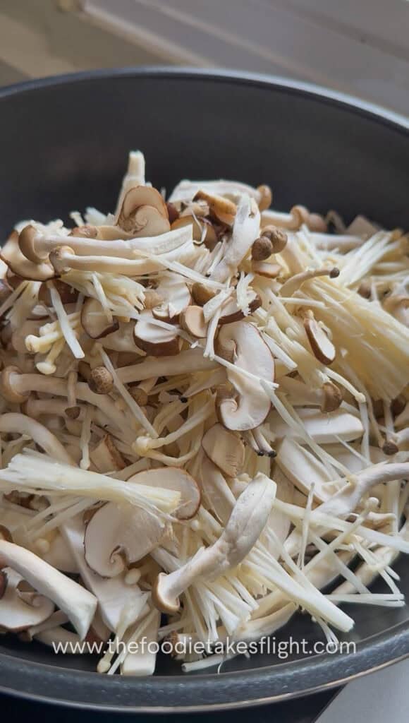 Mushrooms cooking in a dry wok until they release moisture
