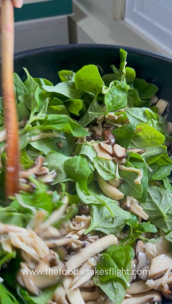 Spinach leaves added to cooked mushrooms after turning off the heat