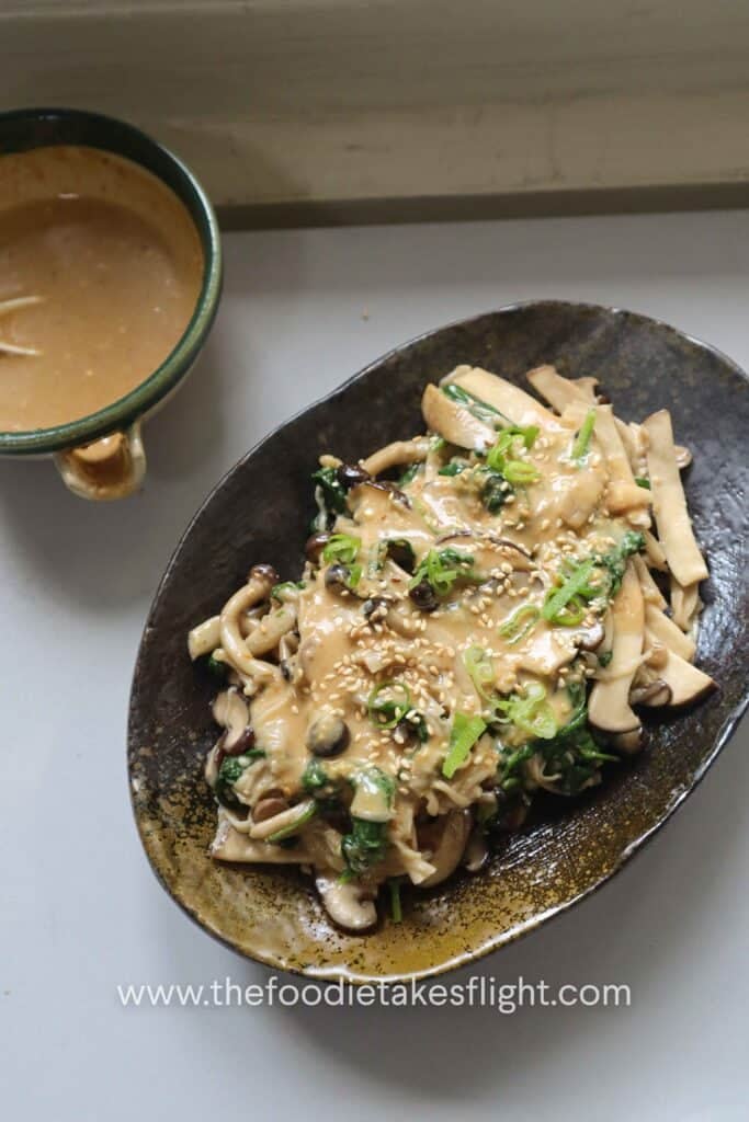 Warm mushroom salad topped with chopped scallions and roasted sesame seeds