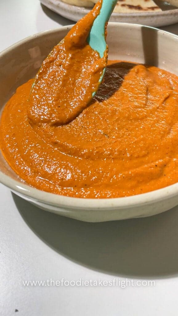 Close-up of smoky roasted red pepper dip with olive oil and herbs