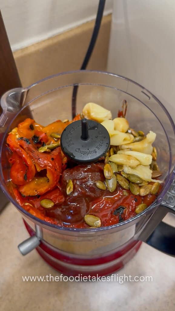Roasted red peppers, roasted garlic, pumpkin seeds, gochujang, mayo, lemon juice, maple syrup, and olive oil added to a food processor