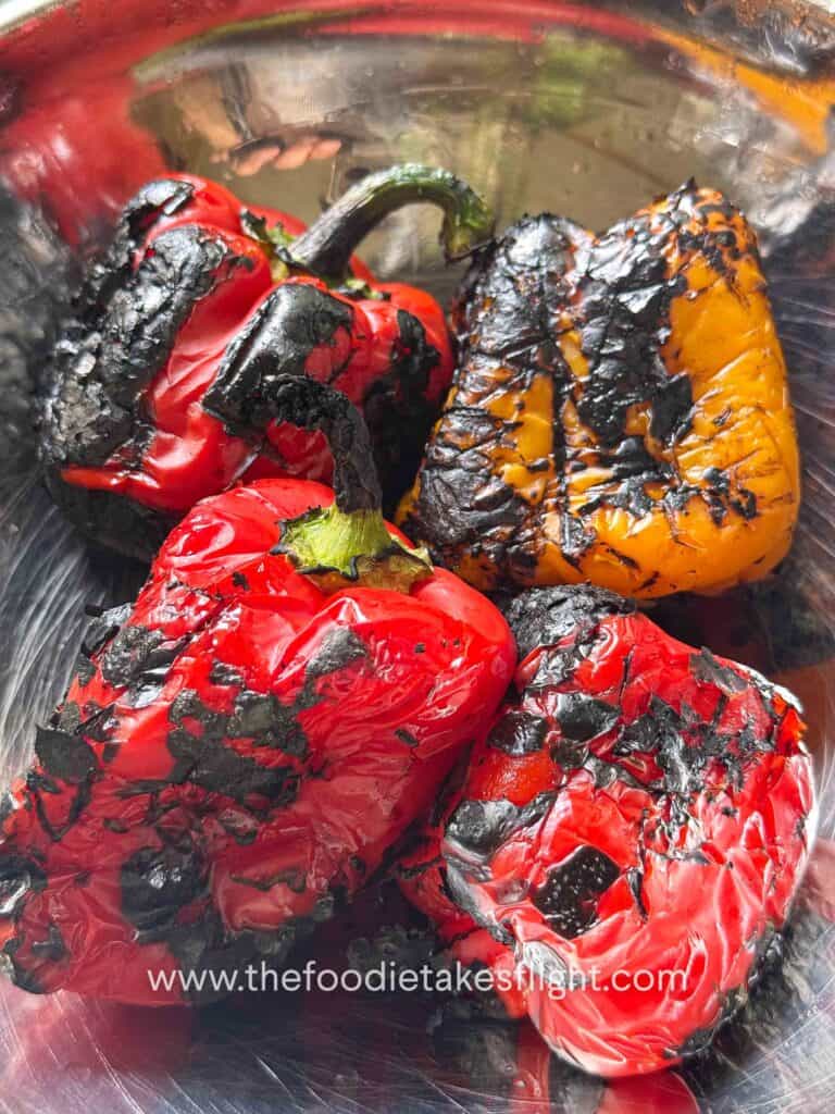 Charred red bell peppers placed in a bowl